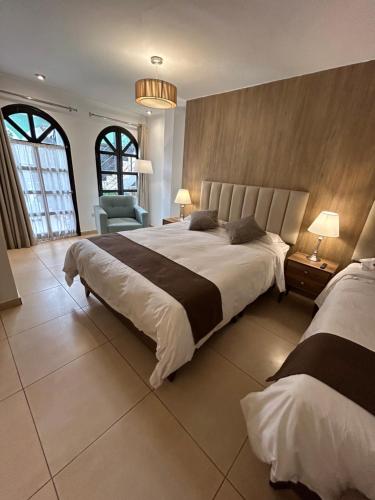 瓦拉斯Habitaciones La Casona的一间大卧室,配有两张床和椅子