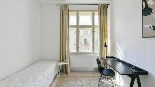 a bedroom with a bed and a desk and a window at Designer Touch 2-bedroom in Picturesque Area in Golčŭv Jeníkov