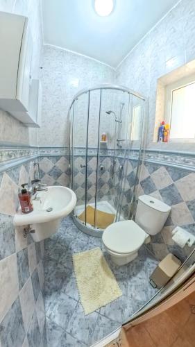 a bathroom with a toilet and a shower and a sink at Blue Sunrise in Birżebbuġa
