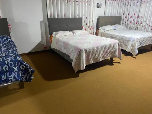 VICTORIA HOUSE - Huancayo - Hualhuas في Hualhuas: سريرين يجلسان في غرفة مع