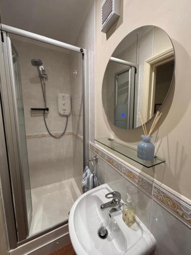 Seagulls Rest - Sheringham في شيرينغهام: حمام مع دش ومغسلة ومرآة