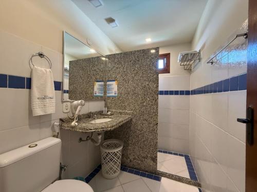 a bathroom with a toilet and a sink and a shower at Hotel Mar de Cabo Frio in Cabo Frio