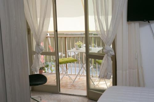 una camera da letto con vista su un balcone con tavolo di B&B The Queen a Ispica