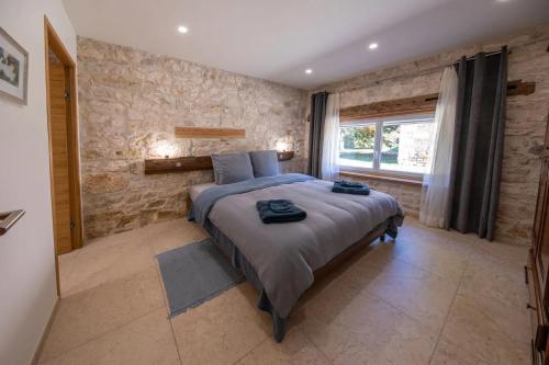 Saint-GeorgesGite Coeur des Ondes - Bleuet的一间带大床和石墙的卧室
