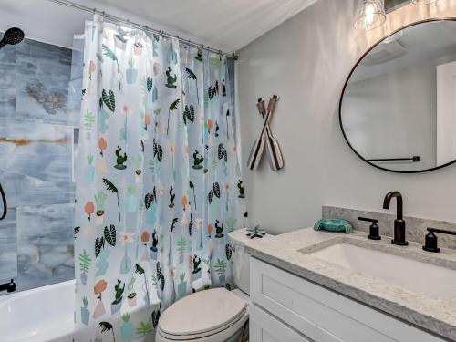 a bathroom with a shower curtain with a toilet and a sink at Lazy Hammock in Tybee Island