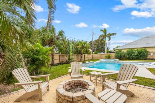 een patio met stoelen en een vuurplaats naast een zwembad bij Cocoa Beach 3BR Oasis - 1 Block To Beach in Cape Canaveral