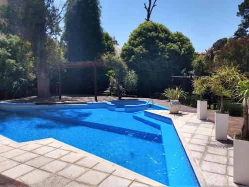 una piscina en un patio con árboles en NOVA Hotel Pinamar, en Pinamar