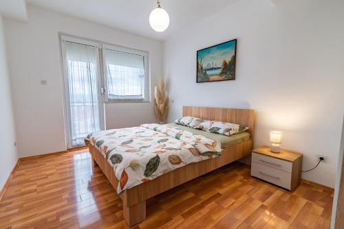 a bedroom with a bed and a wooden floor at Charming & Spacious 2 Bedroom Apartment with a Gorgeous 8th-floor view in Ohrid