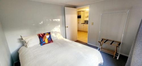 MotungararaCasa de los Tūi的卧室设有一张白色大床和一个走廊