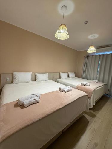two beds sitting next to each other in a room at Pousada Maritaca in Bonito