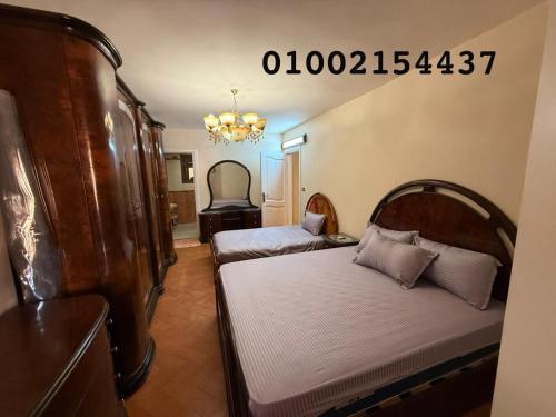a bedroom with two beds and a chandelier at شقه 401عائليه سوبر لوكس في وسط الحي الافرنجي في مركز المدينه in Port Said