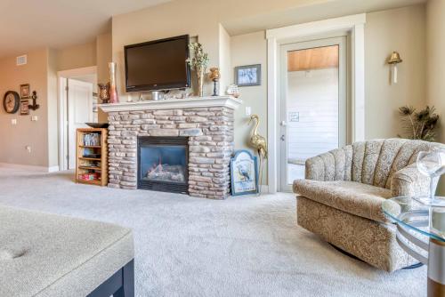 a living room with a fireplace with a tv above it at Rivers Edge at Bridgeport in Seaside