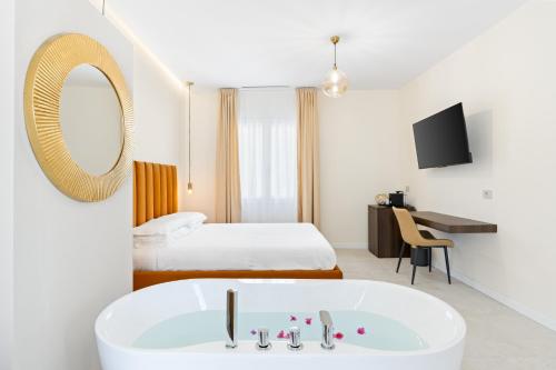 a hotel room with a tub and a bed at Sofì Luxury Suite in Iglesias