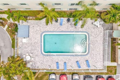 una vista dall'alto di una piscina in un parcheggio di Cape Canaveral Condo Steps from the Beach a Cape Canaveral