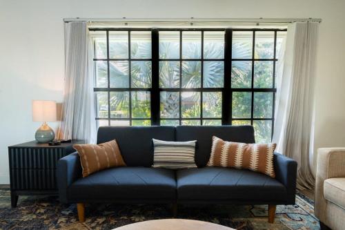 ein blaues Sofa im Wohnzimmer mit großem Fenster in der Unterkunft Cozy Riverfront Home with Pool in Indianola