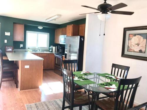 a kitchen with a table with chairs and a ceiling fan at 4 Bedroom Vacation House With Pikes Peak view Pet-friendly in Aurora