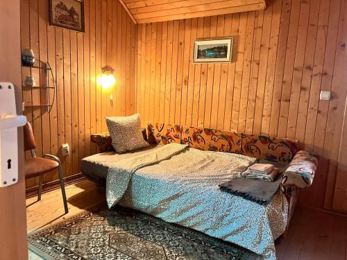 a bedroom with a bed in a room with wooden walls at Memory Lane Cottage – Posada in Comarnic