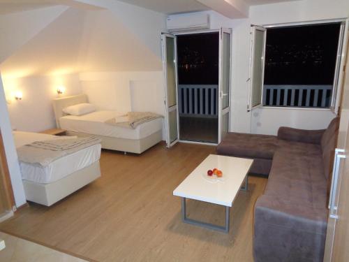 uma pequena sala de estar com uma cama e um sofá em Villa Boka Sunrise Apartments em Herceg Novi