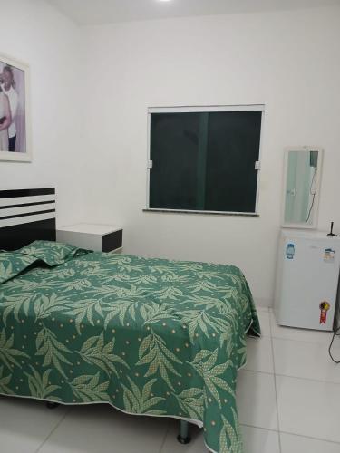 a bedroom with a bed and a flat screen tv at Casa de praia em Barra do Gil in Vera Cruz de Itaparica