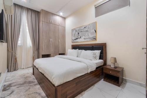 Un dormitorio con una cama grande con cabecero de madera. en Aduni's Place, en Ikeja