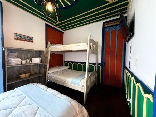 a bedroom with two bunk beds in a room at Hotel Colibri Real in Filandia