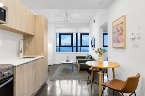 Una cocina y una sala de estar con una mesa y un sofá. en Le William, en Montreal