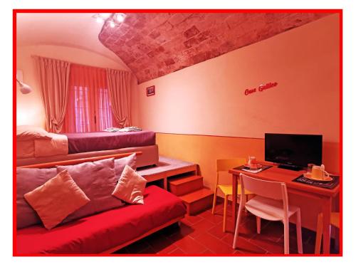 a room with a couch and a desk with a computer at Casa GALILEO- Antiche Dimore Pisane in Pisa