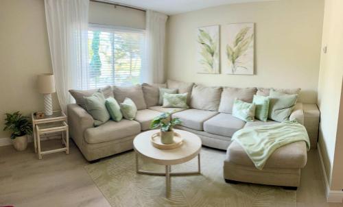 a living room with a couch and a table at Coastal Countdown Relaxed Townhome Near Beach and Rockets in Cape Canaveral