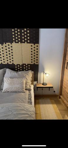 ein Schlafzimmer mit einem Bett und einem Tisch mit einer Lampe in der Unterkunft Cozy apartment with terrace in Malbork