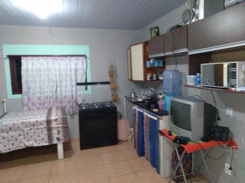 una piccola cucina con TV in camera di Casa na praia a Arroio do Silva