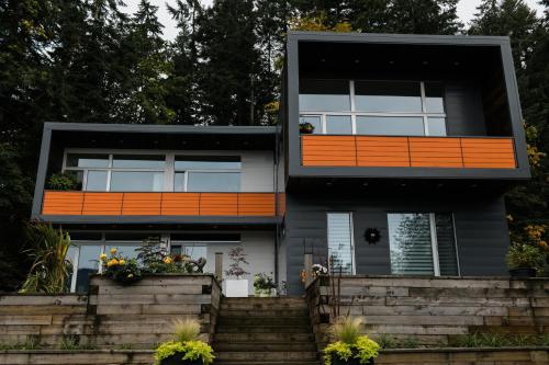 una casa arancione e nera con scale di The Cube Cow Bay Suite a Cowichan Bay