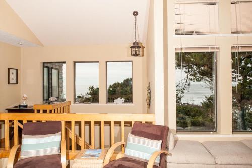 a living room with a table and chairs and windows at Calypso in Lincoln City