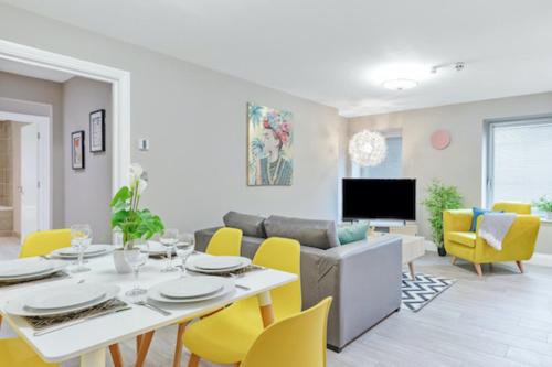 a living room with a table and yellow chairs at Ocean Walk - By My Getaways - Free Parking in Brighton & Hove