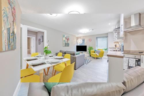a living room and dining room with a table and yellow chairs at Ocean Walk - By My Getaways - Free Parking in Brighton & Hove