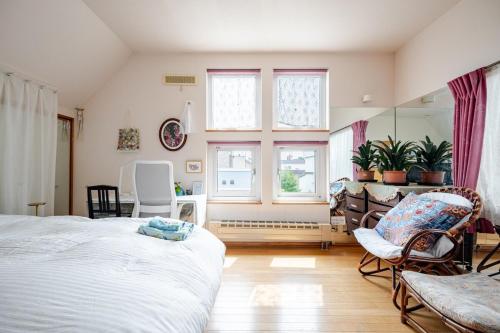 1 dormitorio con cama, sillas y espejo en Sapporoの実家 B&B Yoshida, en Sapporo