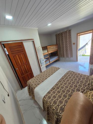 een slaapkamer met een bed en een houten deur bij Chalés Brisa do Mar in Amontada