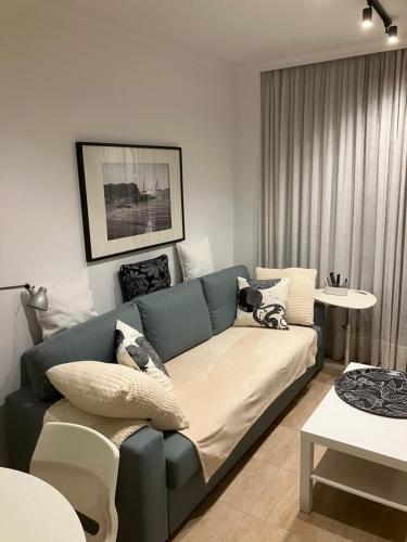 a living room with a blue couch and a table at Arminda in Arguineguín