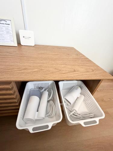 two white trays sitting on top of a wooden table at Luzera Escape - a minimalist and cozy studio unit in Davao City