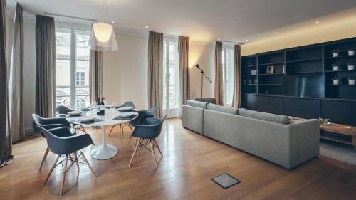 a living room with a couch and a table and chairs at Appartement T4 cours de l'intendance in Bordeaux