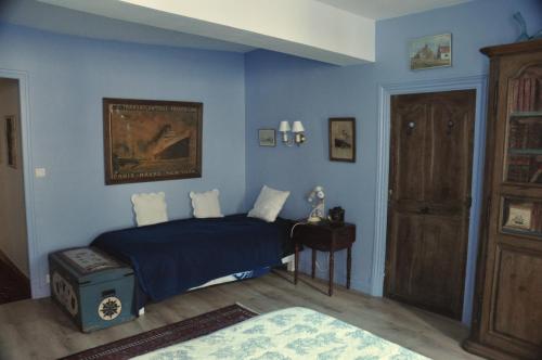 una camera da letto con un letto con una parete blu di Vaste chambre au centre du bourg a Saulieu