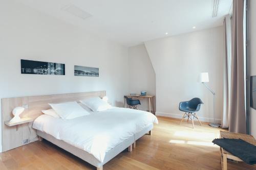 a bedroom with a bed and a desk and a tv at Appartement T4 cours de l'intendance in Bordeaux
