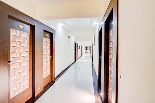 un pasillo de un edificio con puertas y un pasillo largo en Collection O Infocity Metro Station Gandhinagar Formerly Hotel LLP, en Gandhinagar