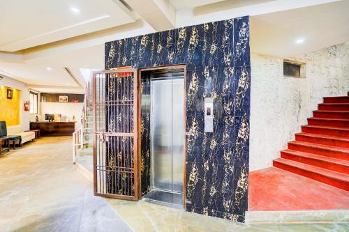 un vestíbulo con una puerta y escaleras en un edificio en Collection O Infocity Metro Station Gandhinagar Formerly Hotel LLP, en Gandhinagar