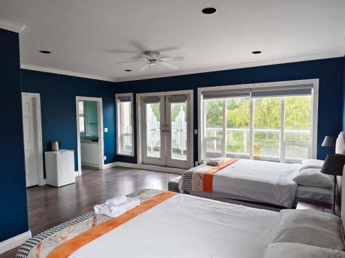 ein Schlafzimmer mit zwei Betten und einer blauen Wand in der Unterkunft Vancouver Airport Blueberry Manor in Richmond