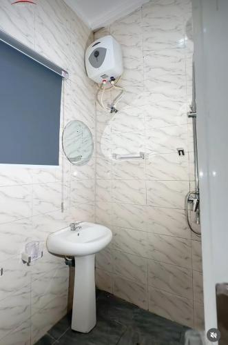 a bathroom with a white sink and a shower at KC Shortlet in Asaba