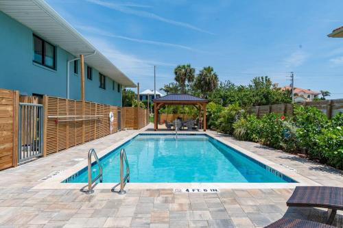 een zwembad met een prieel naast een huis bij 400 South - Unit A in Cocoa Beach