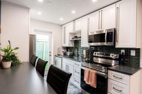 een keuken met witte kasten en zwarte aanrechtbladen bij 400 South - Unit A in Cocoa Beach