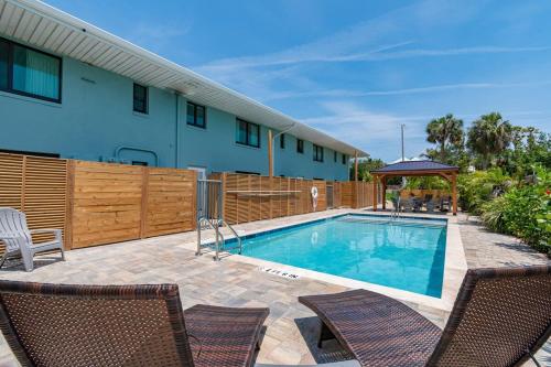 een zwembad met 2 stoelen en een gebouw bij 400 South - Unit B in Cocoa Beach