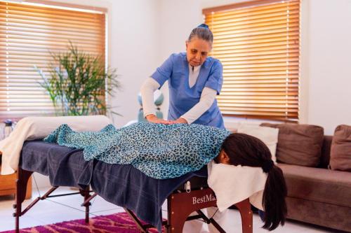 威廉斯塔德Oasis Haven Curacao的一位女士在客厅里熨烫一个女孩的衣服