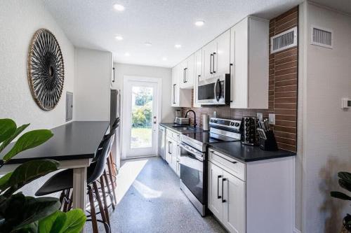 een keuken met witte kasten en zwarte aanrechtbladen bij 400 South - Unit D in Cocoa Beach